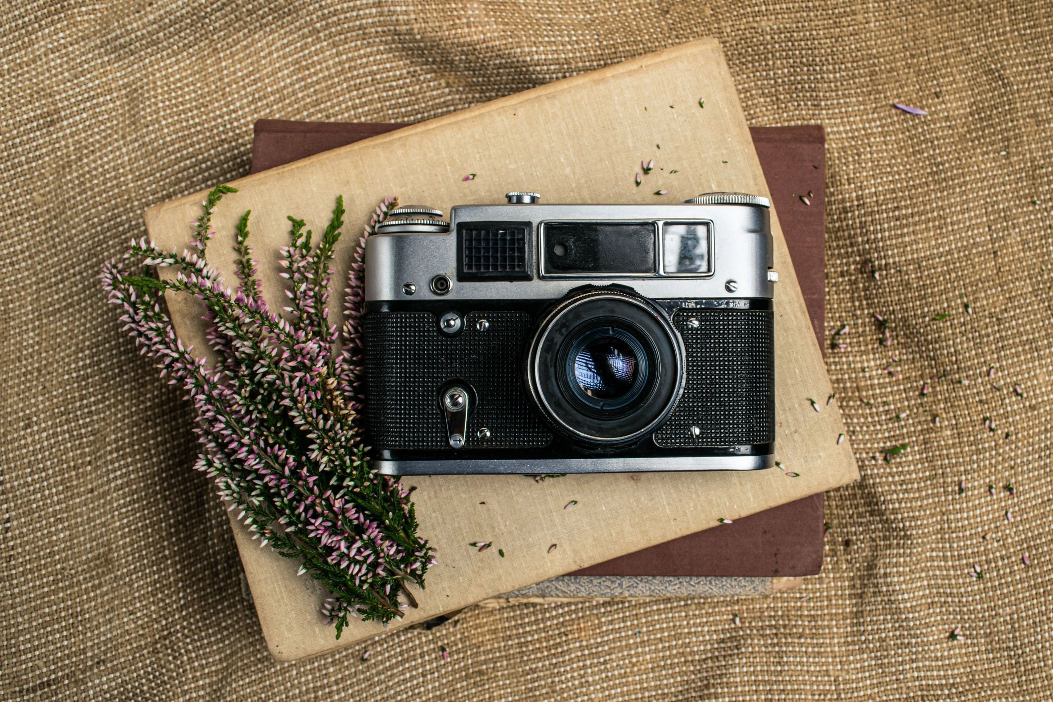 Styled camera composition with books and flowers